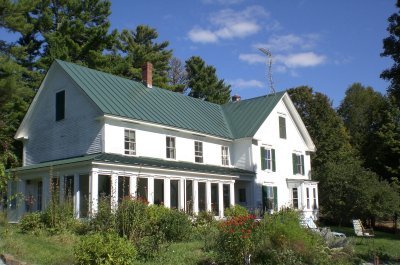 white house with gardens trees view from front